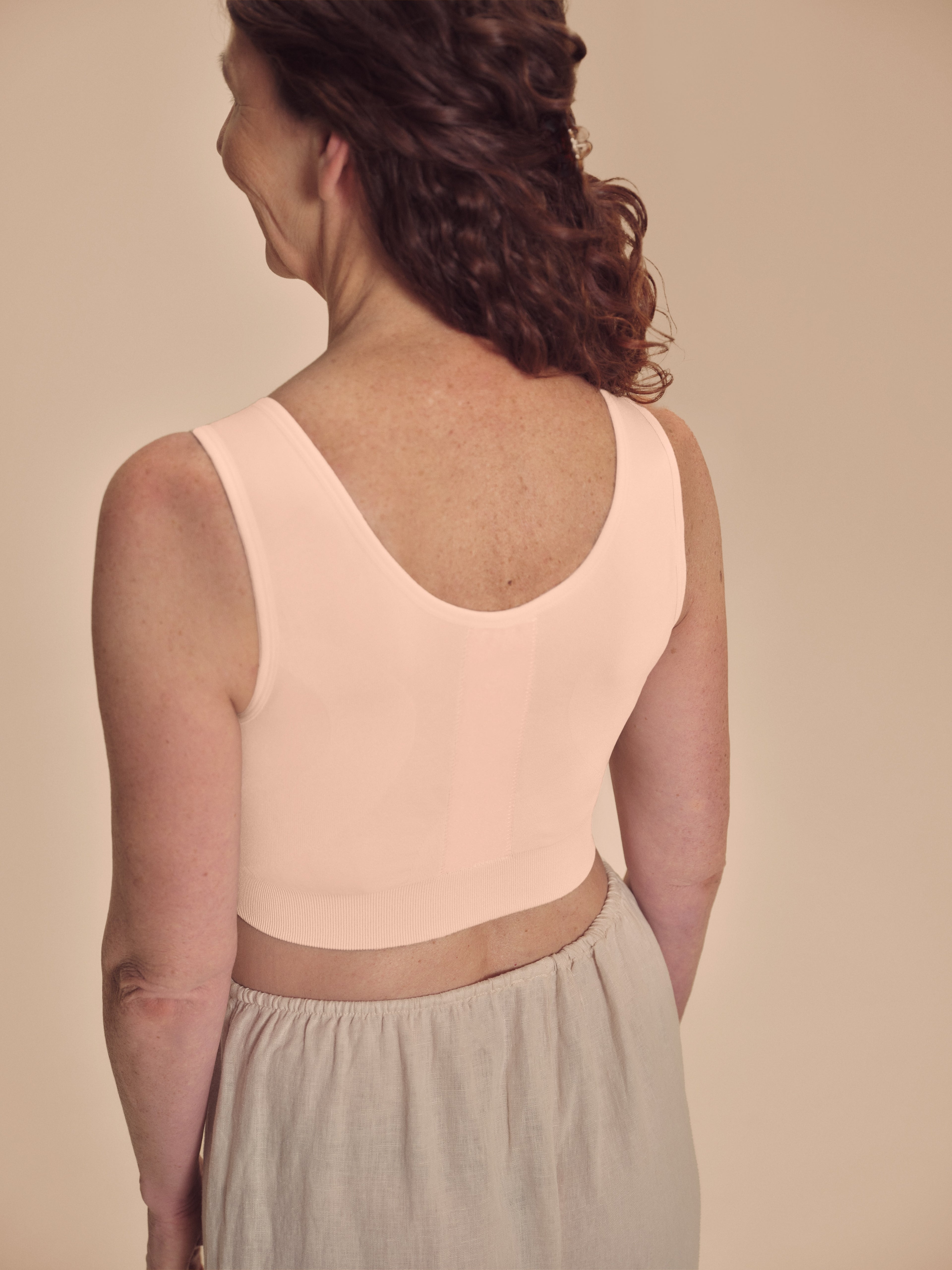 Amoena Pamela post-surgery zip compression bra in rose nude, front view showing supportive design and front zipper closure.