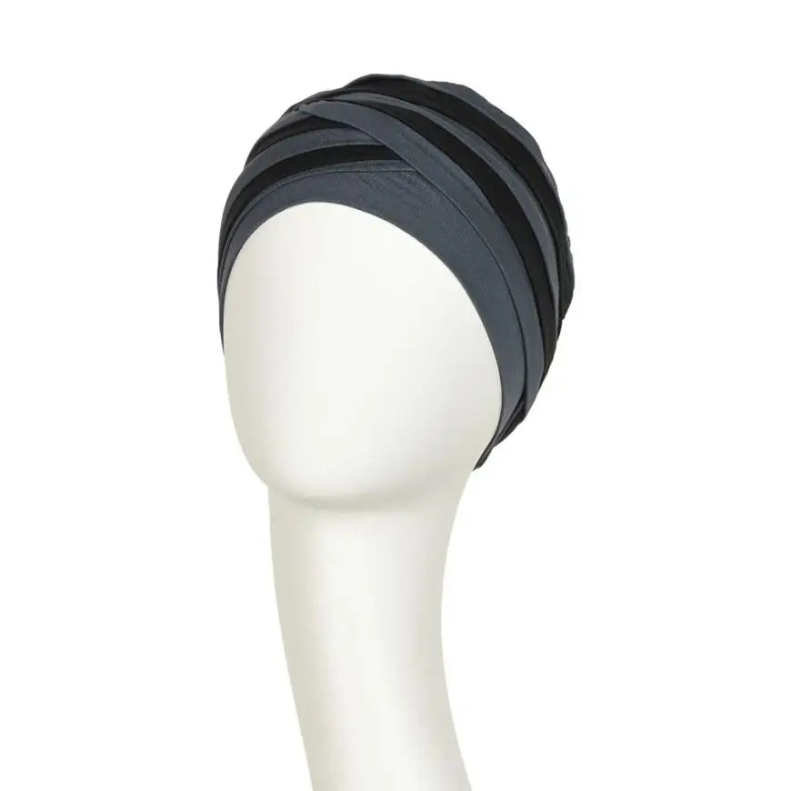 Blue and black Shanti turban hat by House of Christine, styled with a smooth, wrapped fabric for a chic, elegant look.