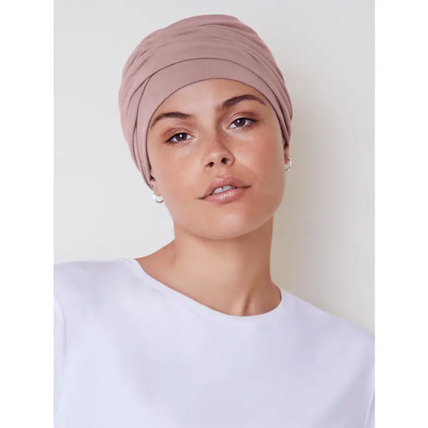 Zoya wearing a stylish HocEmmy V turban hat by HOUSE OF CHRISTINE, crafted from soft fabric in a vibrant color.