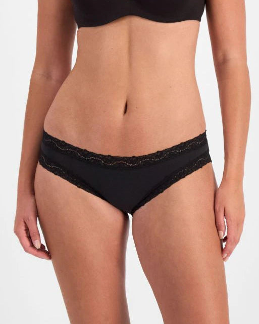 Woman wearing a black bra and panties set on a white background