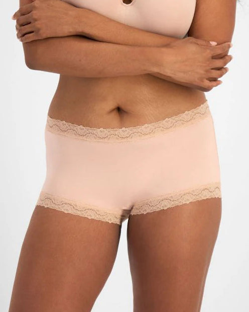 Woman wearing a beige bra and panties set on a white background