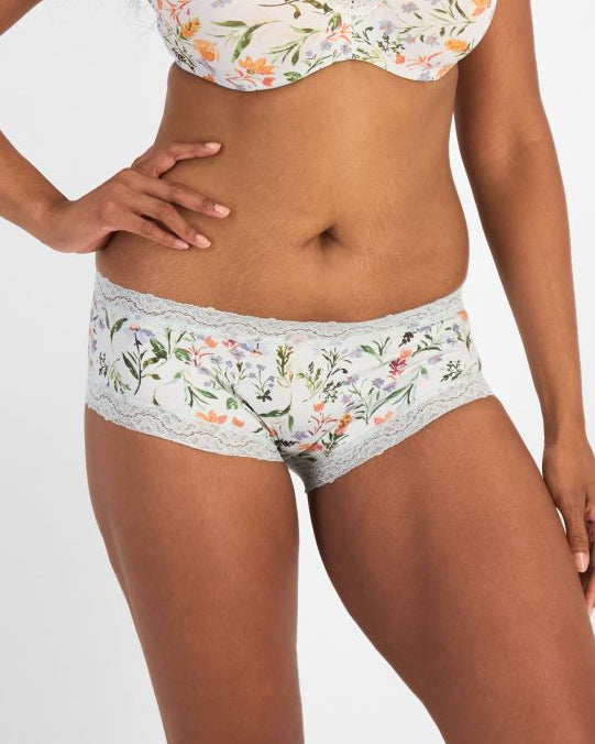Woman wearing a floral bra and panties set on a white background