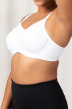 White Triaction sports bra by Triumph, designed for larger cup sizes, featuring adjustable straps and breathable fabric.